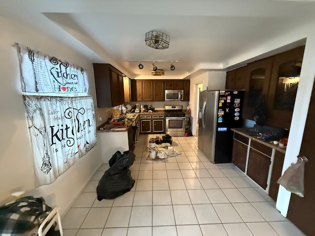 kitchen with light tile patterned floors, dark brown cabinetry, and stainless steel appliances