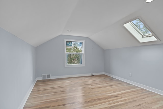 bonus room with light hardwood / wood-style flooring and lofted ceiling with skylight