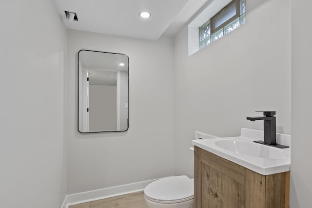 bathroom with wood-type flooring, vanity, and toilet