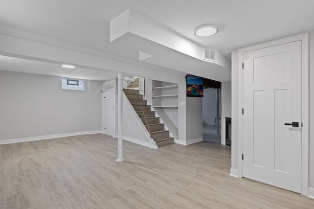 basement with light hardwood / wood-style flooring