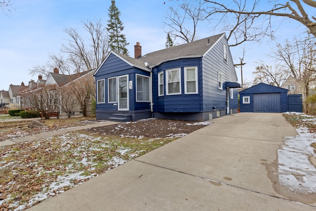 bungalow-style home featuring a garage and an outbuilding