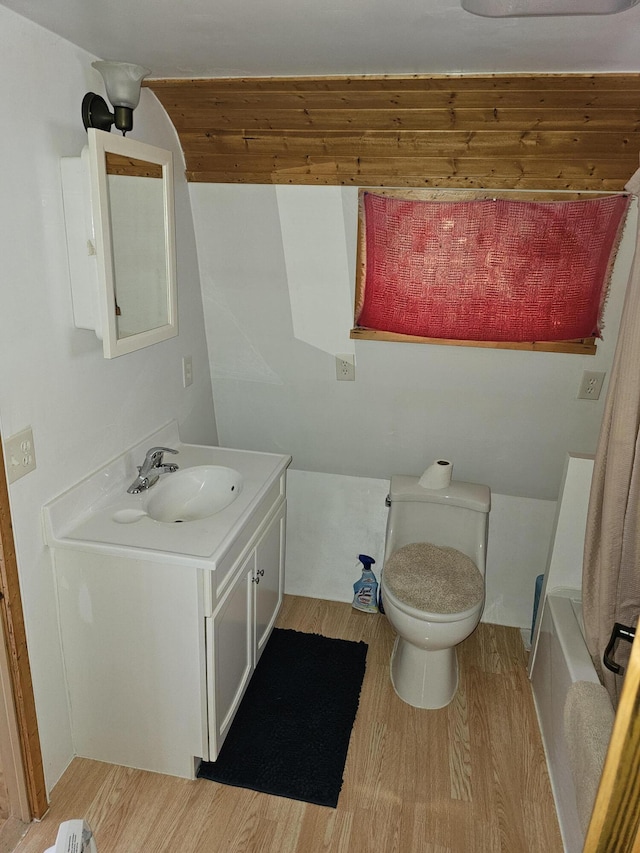 bathroom featuring vanity, a bathing tub, hardwood / wood-style floors, and toilet