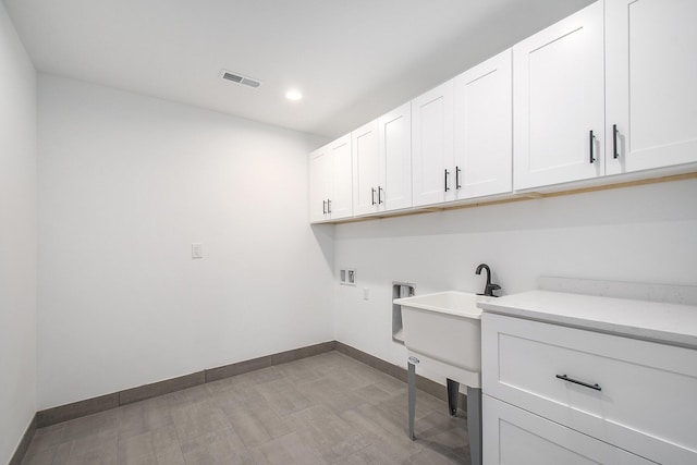 laundry room with sink, hookup for a washing machine, cabinets, and light hardwood / wood-style flooring