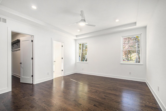 unfurnished bedroom with ceiling fan, dark wood-type flooring, and multiple windows