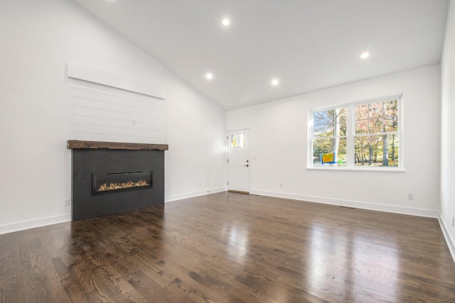 unfurnished living room featuring dark wood-type flooring and high vaulted ceiling