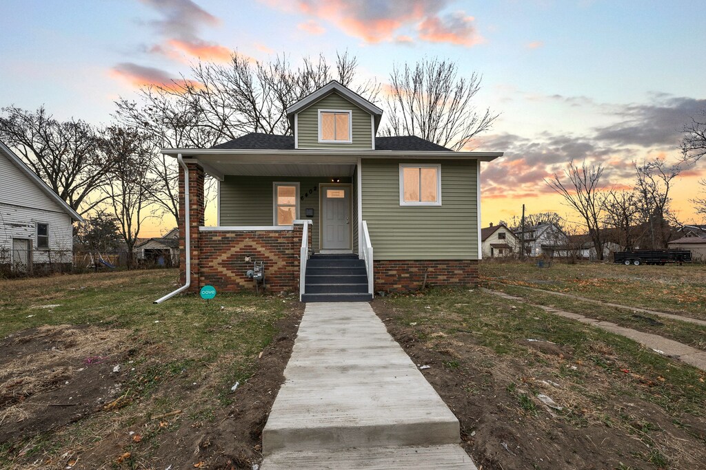 bungalow featuring a porch and a yard