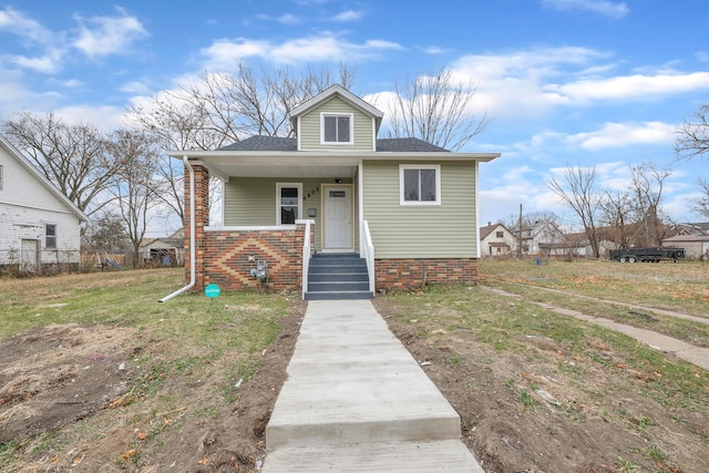 bungalow with covered porch and a front yard