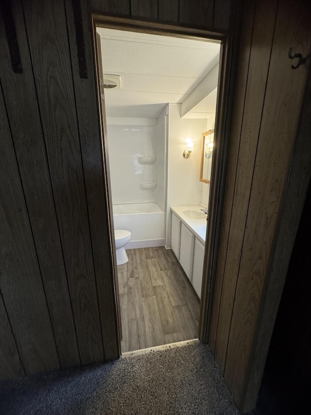 full bathroom featuring wood-type flooring, toilet, shower / washtub combination, and sink