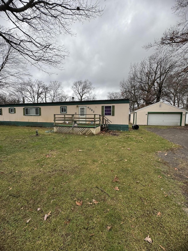 manufactured / mobile home with a garage, a deck, an outbuilding, and a front lawn