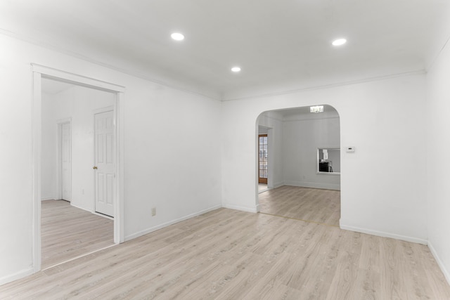 empty room with light hardwood / wood-style floors and ornamental molding