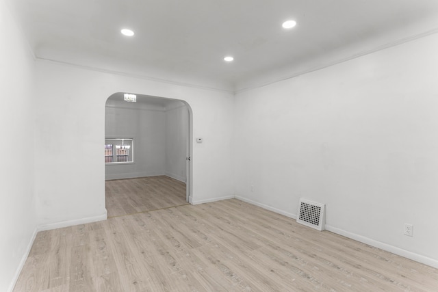 spare room featuring light hardwood / wood-style flooring and ornamental molding