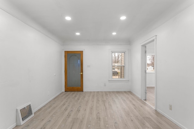 spare room with light wood-type flooring and ornamental molding