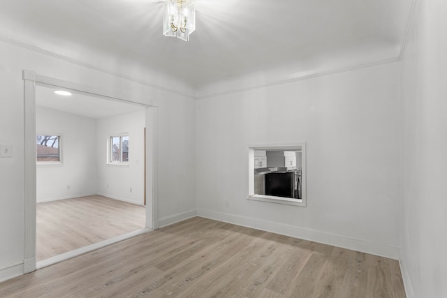 spare room with light hardwood / wood-style floors and lofted ceiling