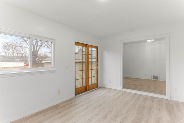 spare room with light wood-type flooring and french doors