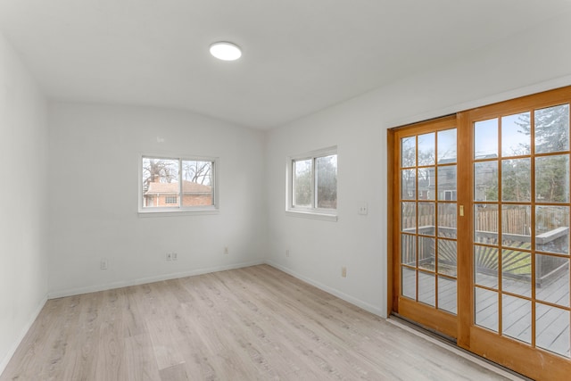 unfurnished room with light hardwood / wood-style floors and vaulted ceiling