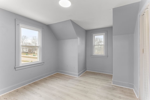 bonus room with vaulted ceiling and light wood-type flooring