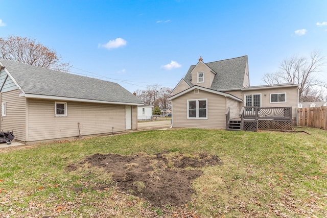 rear view of property with a yard and a deck