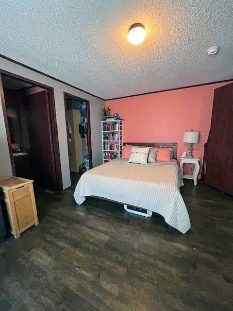 bedroom featuring a textured ceiling and dark wood-type flooring