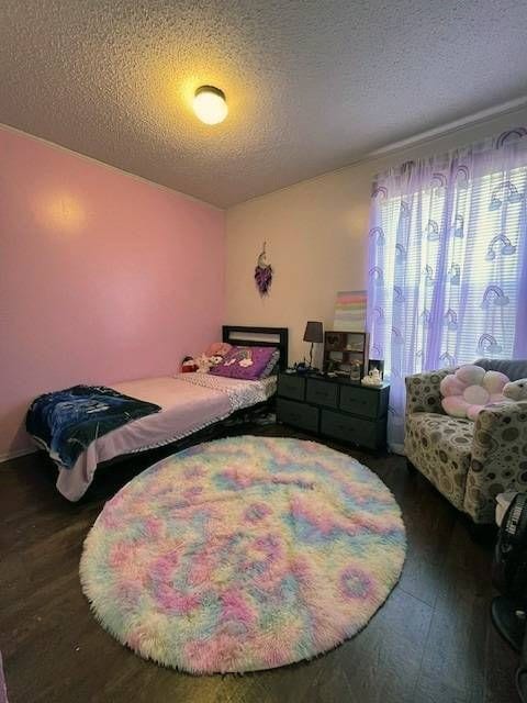 bedroom with dark wood-type flooring and a textured ceiling