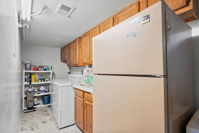 clothes washing area with washer and dryer and cabinets