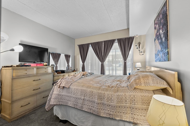 bedroom with dark colored carpet and a textured ceiling