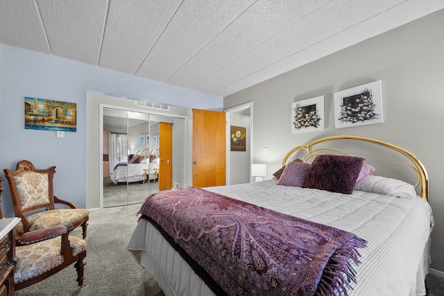 bedroom with carpet flooring, a textured ceiling, and a closet