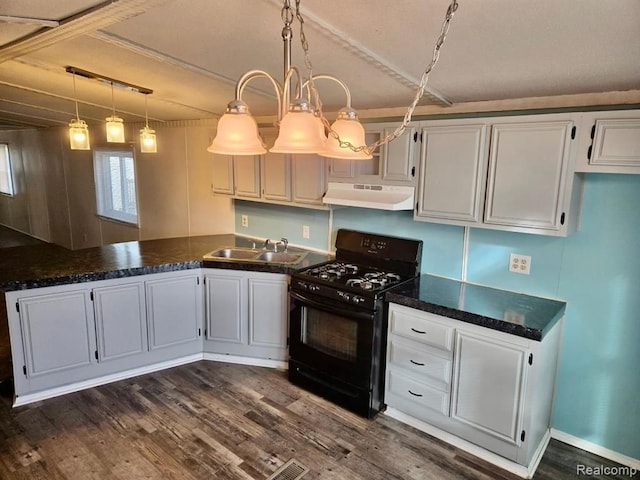 kitchen featuring white cabinets, black gas range oven, hanging light fixtures, and sink