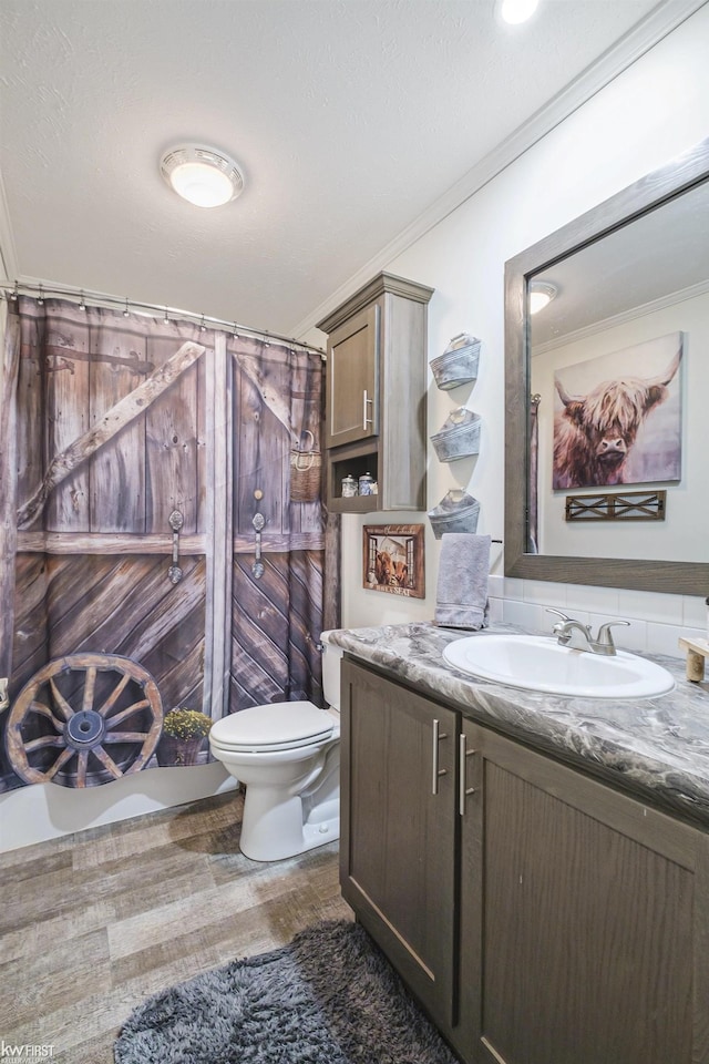 bathroom featuring hardwood / wood-style flooring, vanity, toilet, and ornamental molding