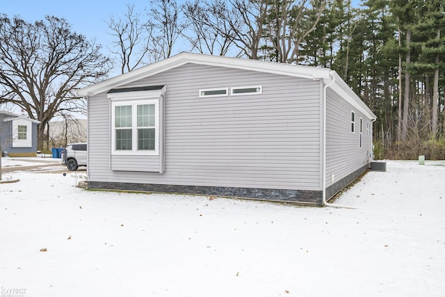 view of snowy exterior featuring central AC