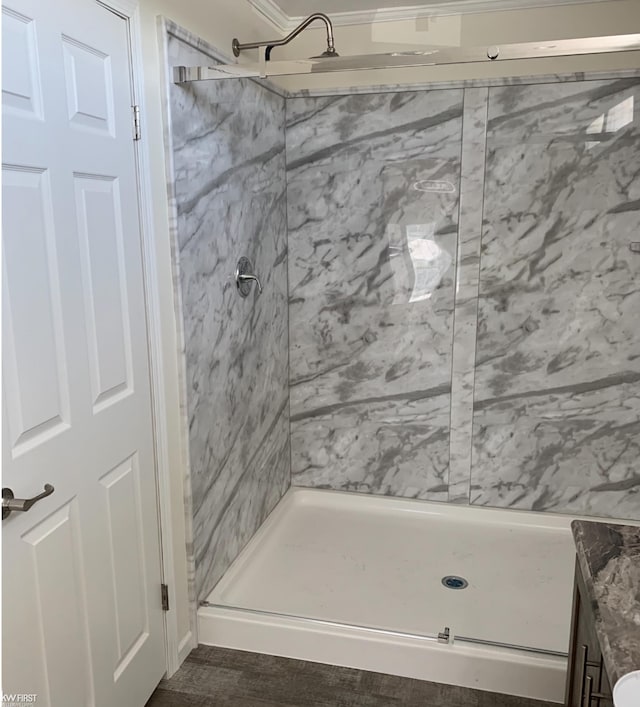 bathroom with wood-type flooring and tiled shower