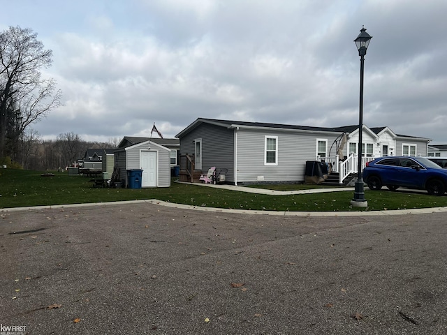 view of front facade with a shed and a front lawn