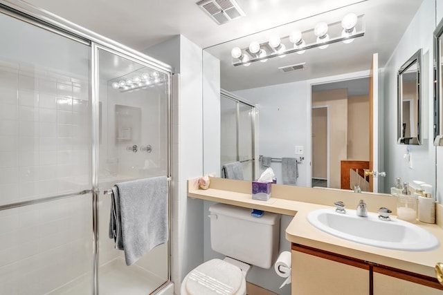 bathroom with a shower with door, vanity, and toilet