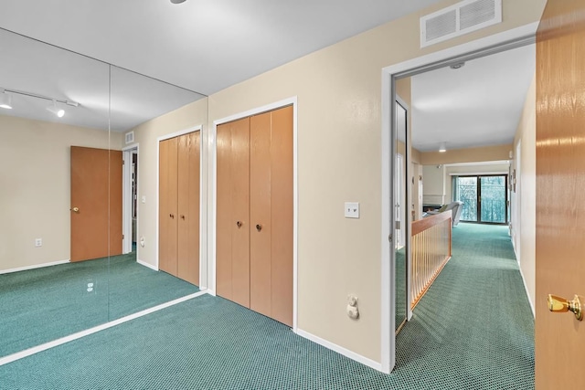 interior space featuring carpet and track lighting