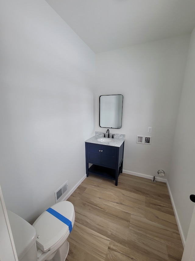 laundry room featuring baseboards, visible vents, hookup for a washing machine, light wood-style floors, and a sink