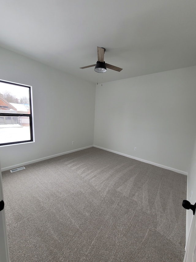 spare room with a ceiling fan, carpet, visible vents, and baseboards