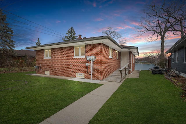 property exterior at dusk with a yard