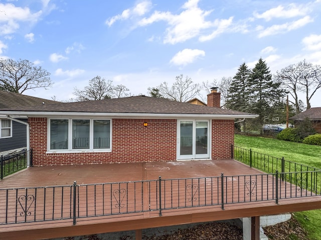 rear view of property with a deck and a yard