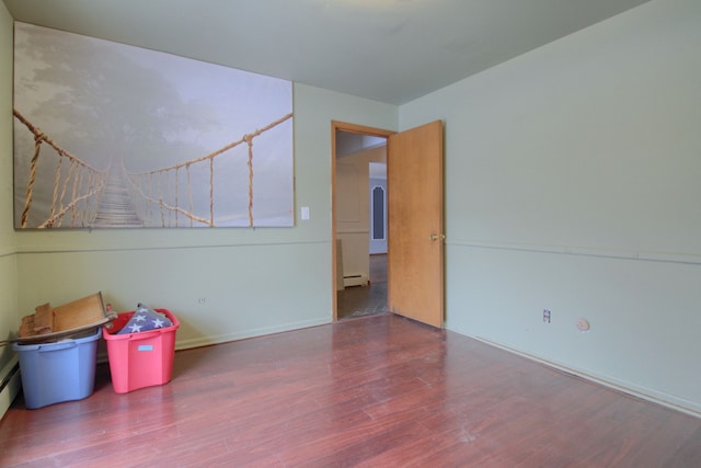 interior space featuring baseboard heating and wood-type flooring