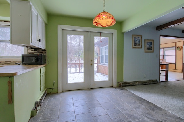 doorway to outside featuring carpet floors, a wealth of natural light, french doors, and beamed ceiling