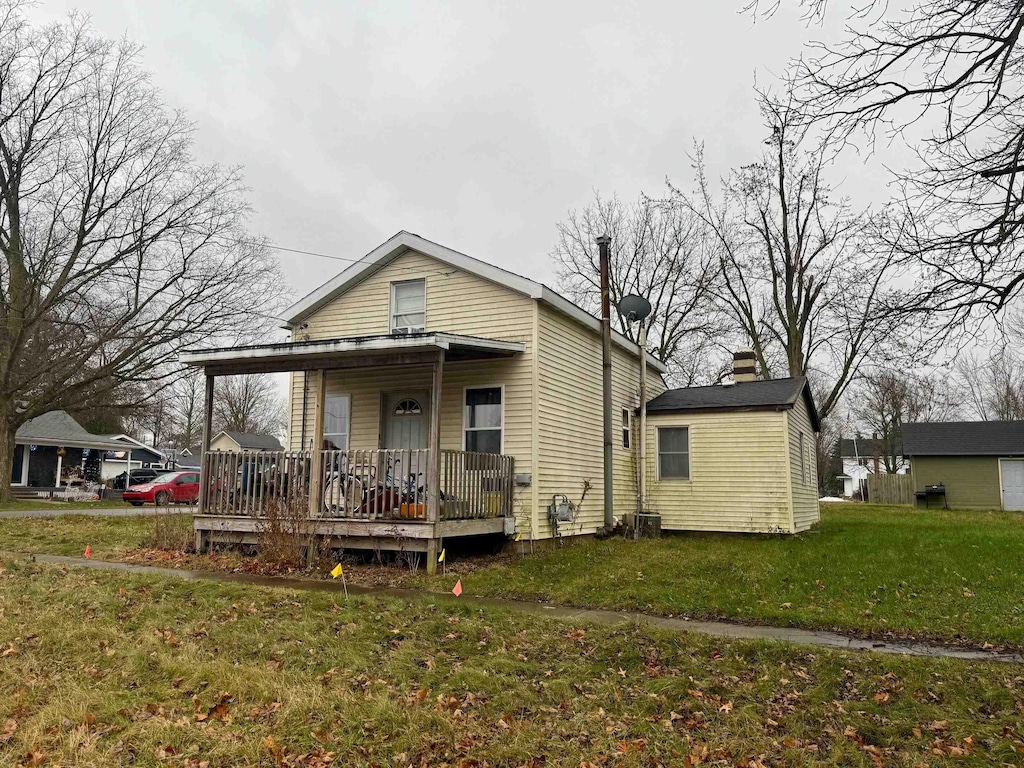 view of front of home with covered porch and a front lawn