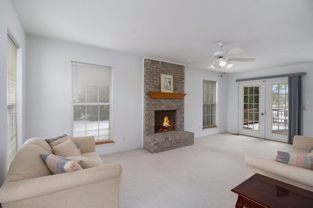 living room with light carpet, french doors, a brick fireplace, and ceiling fan