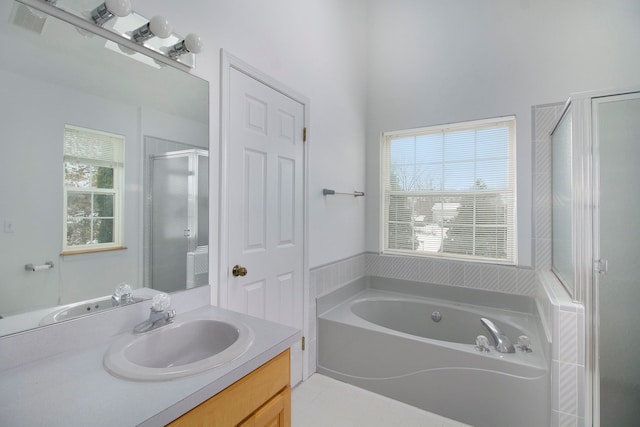 bathroom featuring tile patterned flooring, vanity, independent shower and bath, and a wealth of natural light