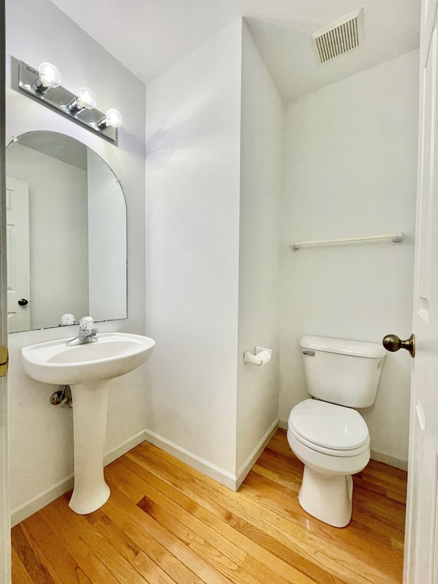 bathroom featuring toilet and wood-type flooring