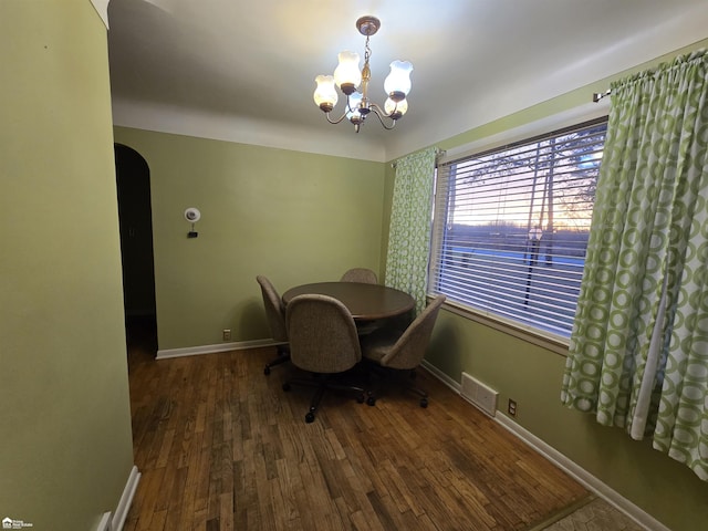 unfurnished dining area with dark hardwood / wood-style flooring and an inviting chandelier