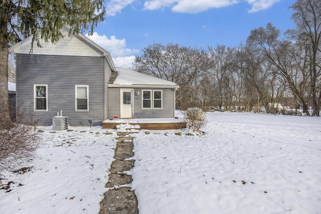 snow covered property featuring central AC