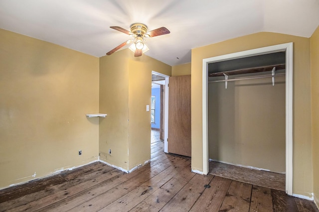 unfurnished bedroom featuring ceiling fan, a closet, lofted ceiling, and hardwood / wood-style flooring