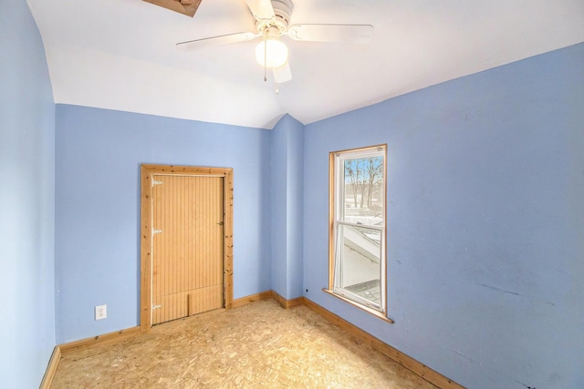 empty room with ceiling fan and vaulted ceiling