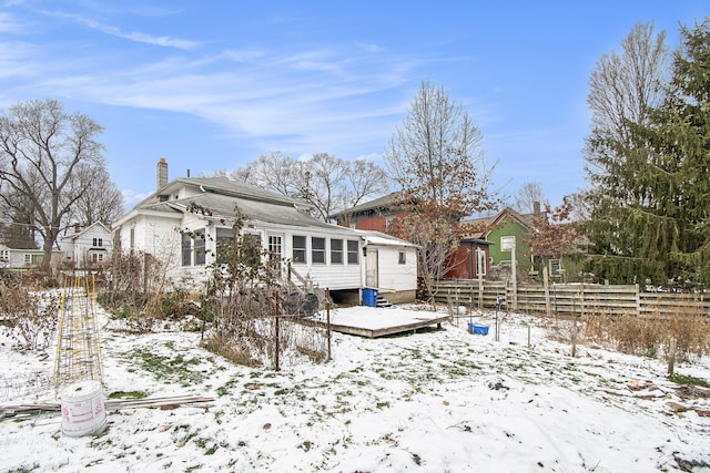 snow covered rear of property featuring a wooden deck