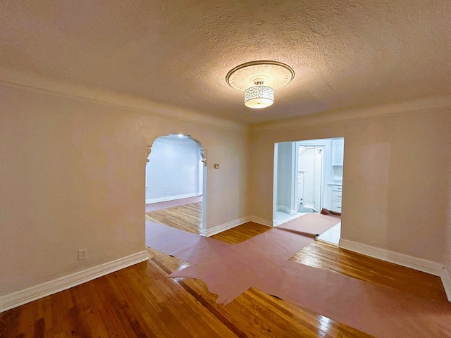 unfurnished room with a textured ceiling and hardwood / wood-style flooring