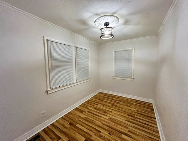 empty room featuring hardwood / wood-style flooring and ornamental molding